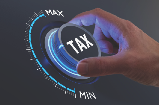 Hand adjusting a dial labeled TAX — impuestos personales y empresariales